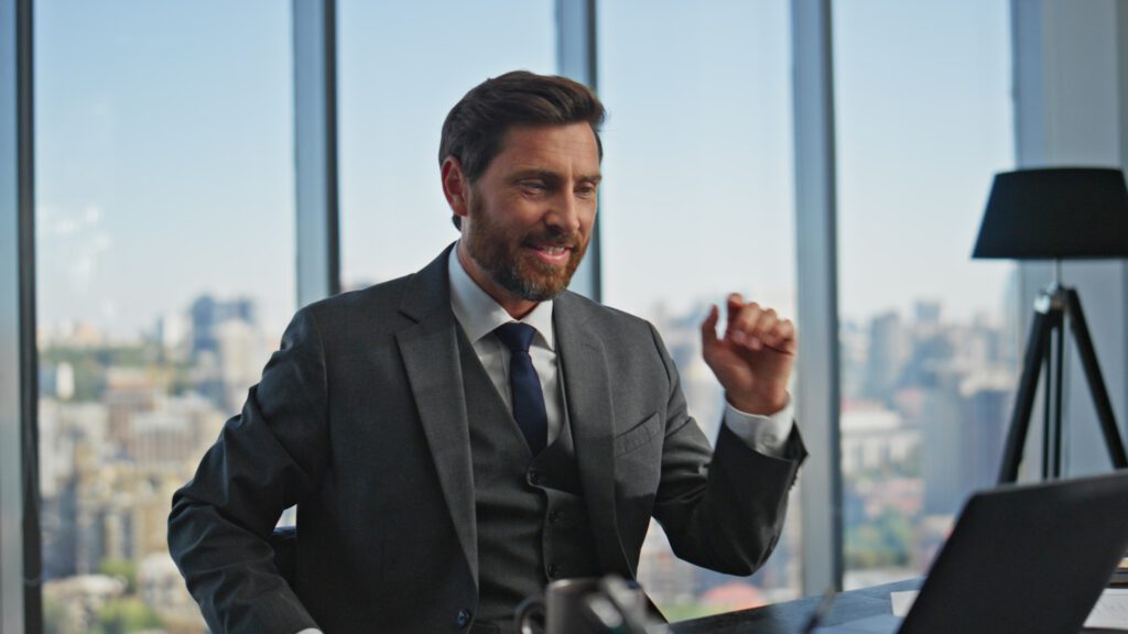 Sales man talking web conference in panoramic office. Smiling manager calling